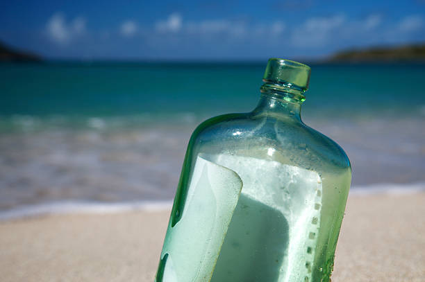 послание в бутылке на пляже крупным планом - stranded message in a bottle island document стоковые фото и изображения