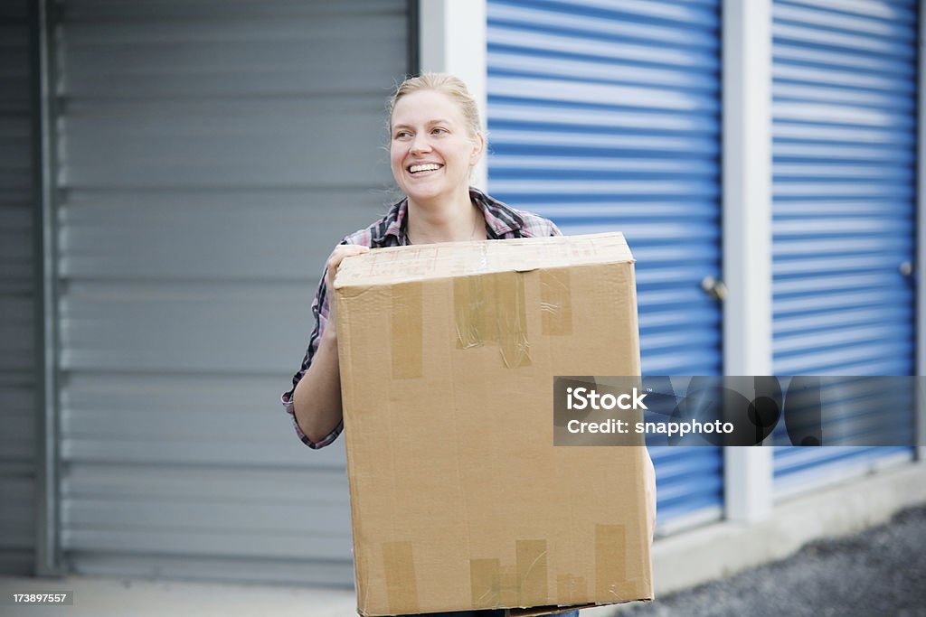 Femme avec boîte en dehors de l'unité de stockage en libre-service - Photo de Self-stockage libre de droits