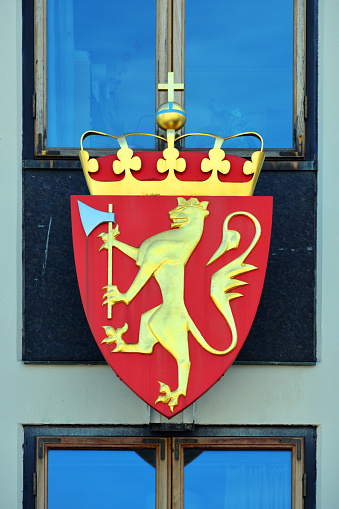 Oslo, Norway: national emblem - The state arms of Norway date from the early Middle ages, the current version was introduced in 1905 when King Haakon VII became king of Norway and modernized in 1992 - yellow crowned rampant lion bearing a golden crown and holding a yellow axe with silver blade over a red shield - golden crown with orb and cross.