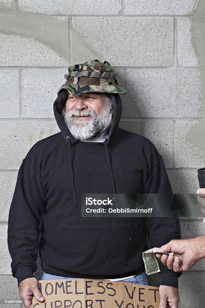 Only A Buck? A homeless veteran asks  for help on a street corner and smirks at a one dollar bill. Homelessness Stock Photo