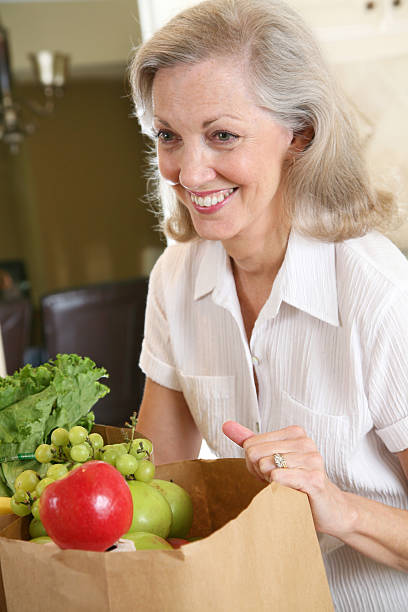 istock Pretty Woman Laughing While Setting Down Grocery Bags 173898091