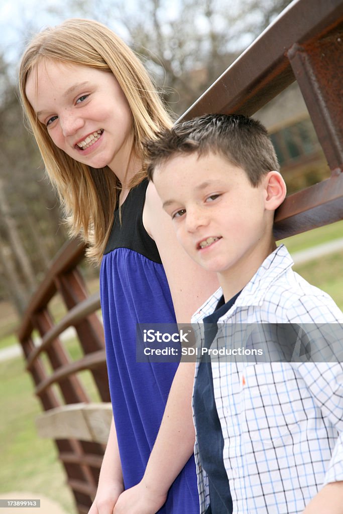Zwei junge lächelnd während Kinder, die Spaß im park - Lizenzfrei Blick in die Kamera Stock-Foto