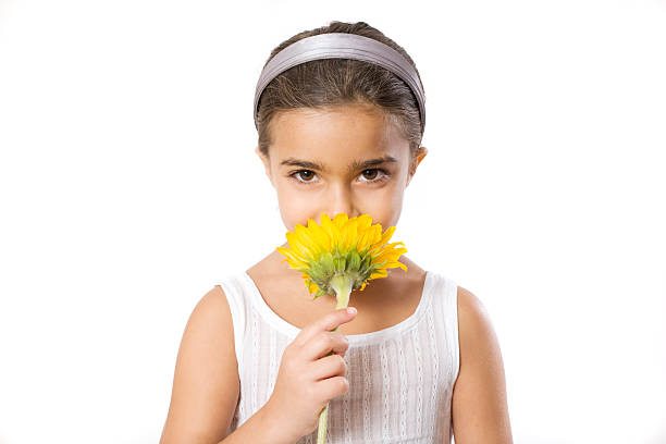 Portrait of little girl smelling a flower stock photo