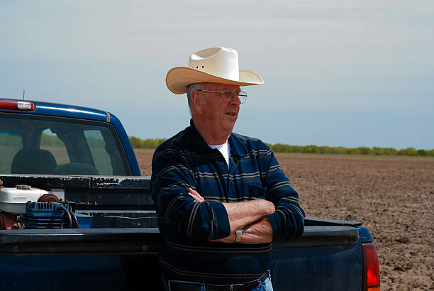 South Texas Rancher with Cowboy Hat Leaning against a Truck stock photo