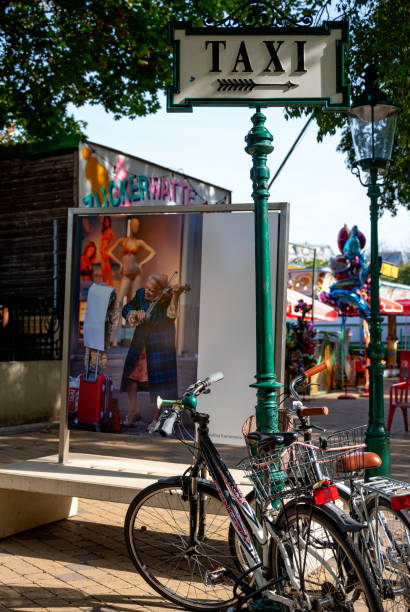 atmospheric scene from the Viennes funfair Prater with bycicles, taxi sign and a photo with an old female street musician in autumnally sunlight, Austria