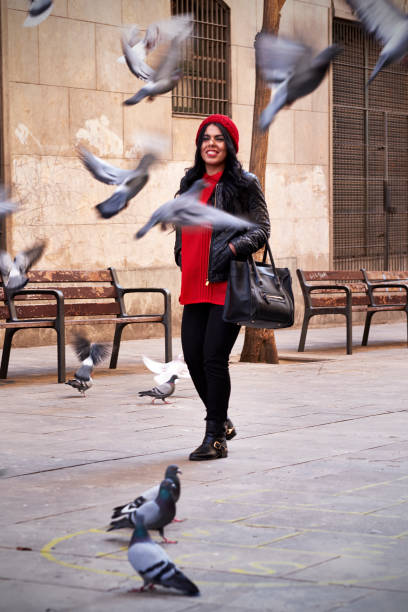 istock Young woman walking surrounded by flying pigeons 1738996977