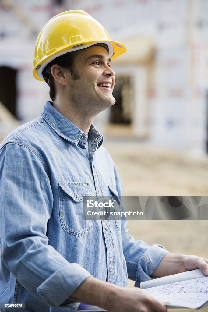 Homem a segurar projectos de construção usando Capacete de proteção - Royalty-free Adulto Foto de stock