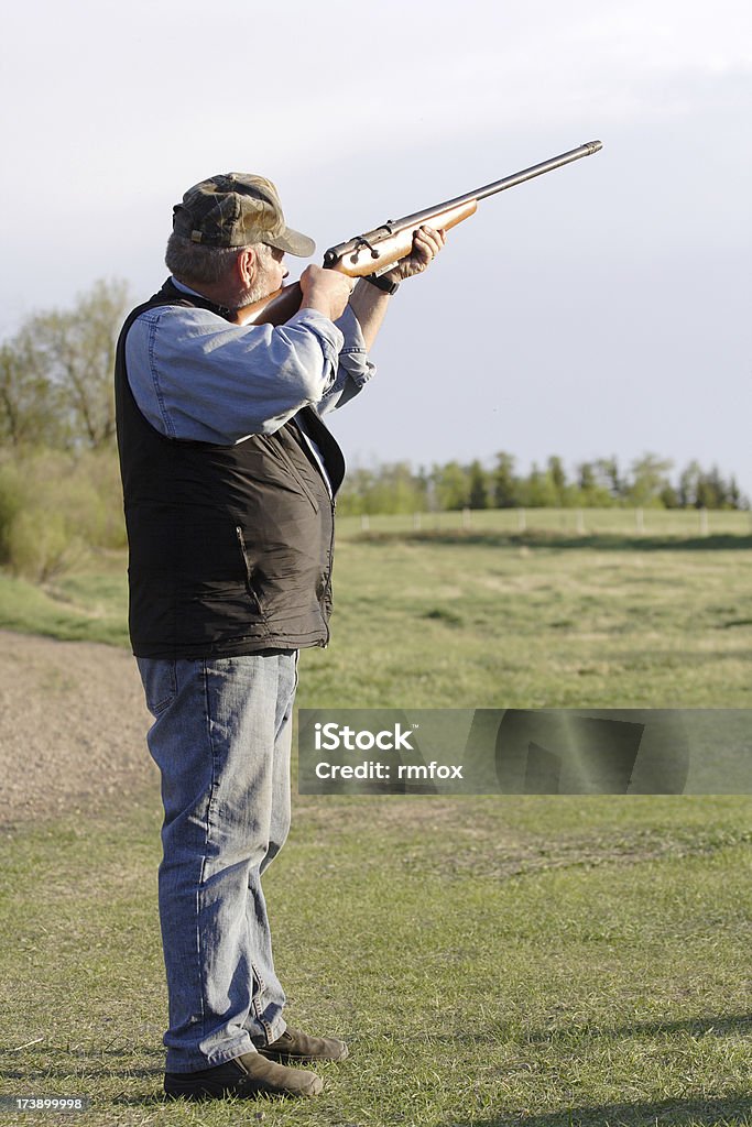 Target Practice Man shooting a shotgun. Outdoors Stock Photo