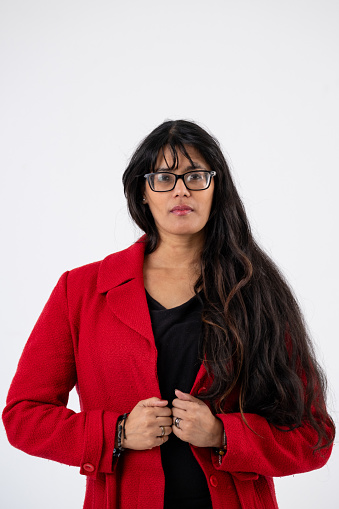 A portrait against a white background of a confident black woman with glasses and long black hair.