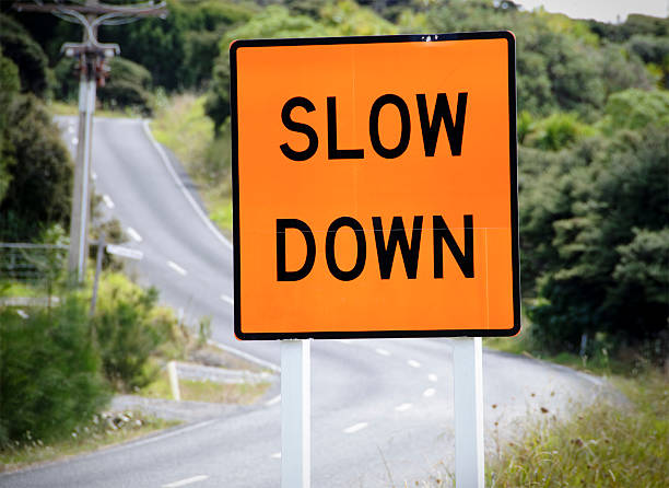"slow down" sign - slow stok fotoğraflar ve resimler