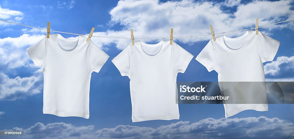 three t-shirts white t-shirts hanging on a washing line Clothesline Stock Photo