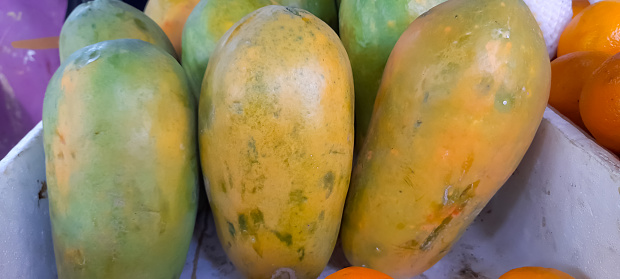 Fresh organic ripe papaya fruit at local market, pile of healthy ripe papaya fruit assorted for sale at roadside fruit shop.