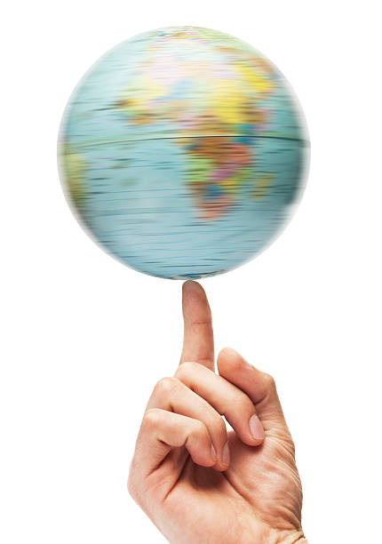 Spinning Globe "A globe spinning on the tip of a finger, isolated on white" finger spinning globe stock pictures, royalty-free photos & images