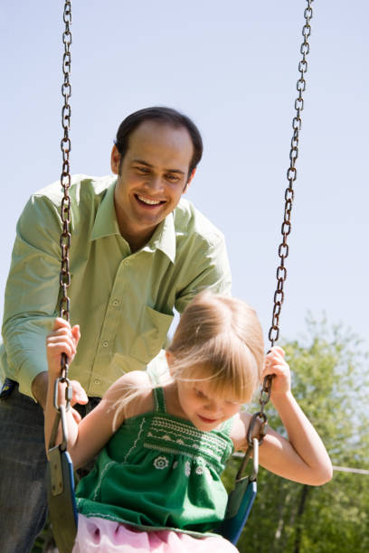 istock Child and Father Playing on Swing Set 173902487