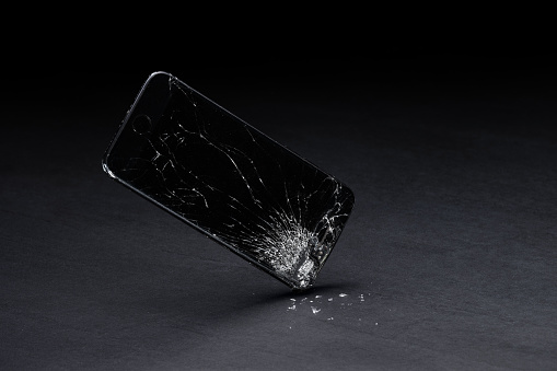 Black smart phone falling and breaking.