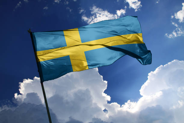 national flag of sweden waving in the wind on a clear day. - day sky swedish flag banner imagens e fotografias de stock