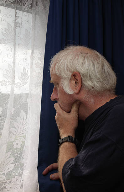 istock senior man looks out window - anxious nervous 173903551