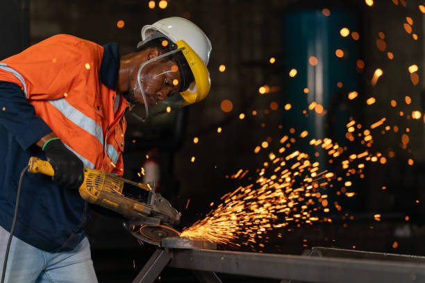 istock Industrious worker stands with unwavering focus, wielding an electric grinding tool. In a mesmerizing display of skill and precision, they work diligently to grind the metal surface to perfection. Every movement is calculated. 1739038950