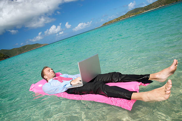 istock Businessman Floating on a Lilo Working Laptop 173904455
