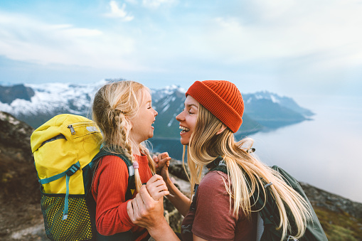 Mother playing with daughter child outdoor hiking in Norway together happy family lifestyle traveling in mountains active vacations woman laughing with kid Mother's day holiday