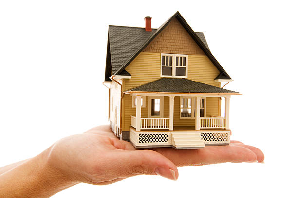 istock Miniture model house sitting on human hand isolated white 173905025