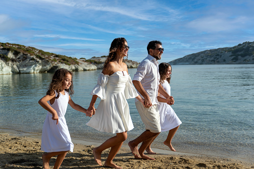 happy couple with two daughters by the sea