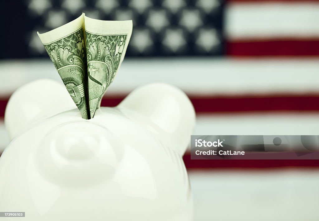 Back Hander Macro shot of piggy bank from behind with money, against an American flag. American Culture Stock Photo