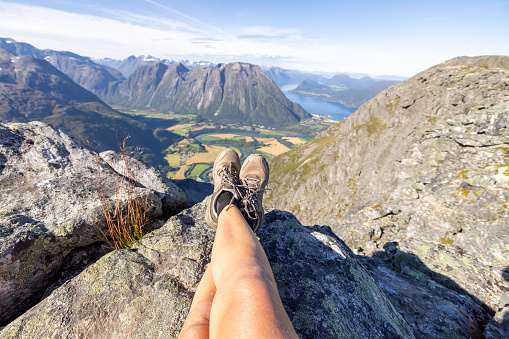 Young woman hiking in a beautiful scenery in Summer enjoying nature and the outdoors.\nNorway
