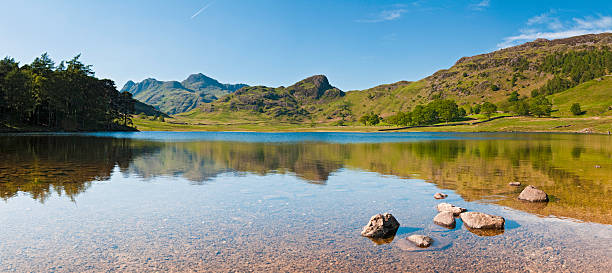 English Lake District tranquil mountain tarn reflected panorama "Clear blue summer skies, rocky mountain summits and lush green high country pasture reflecting in the still waters of Blea Tarn, deep in the beautiful English lake District National Park. ProPhoto RGB profile for maximum color fidelity and gamut." langdale pikes stock pictures, royalty-free photos & images
