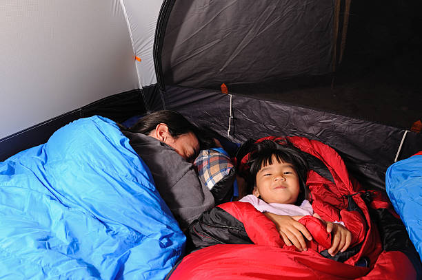 Little Girl Awake in Sleeping Bag While Camping stock photo