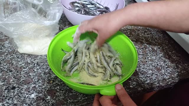 Woman preparing anchovy in kitchen