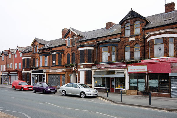 Run-down shops "Row of shops in an inner city area. Many are boarded up and in disrepair. This is Moss Side, Manchester, UK." run down neighborhood stock pictures, royalty-free photos & images