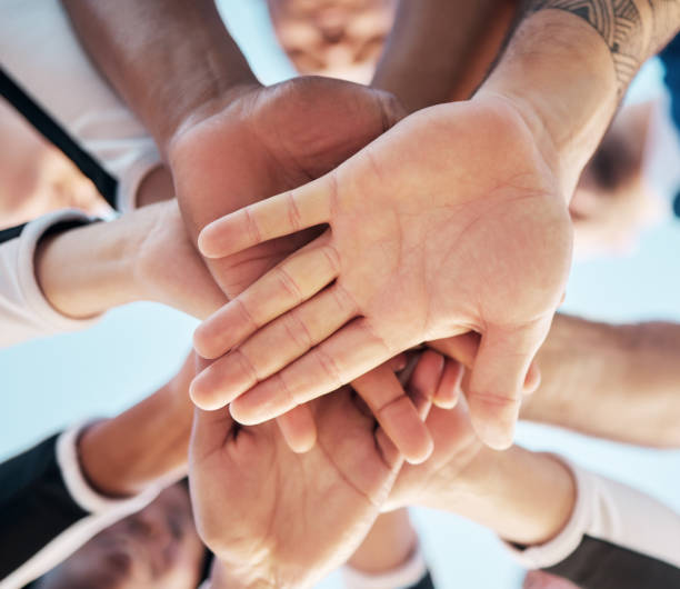 istock Hands, together and people in huddle for support and solidarity in community with low angle view. Palm, team building or collaboration with trust, mission in partnership or alliance with synergy 1739069637