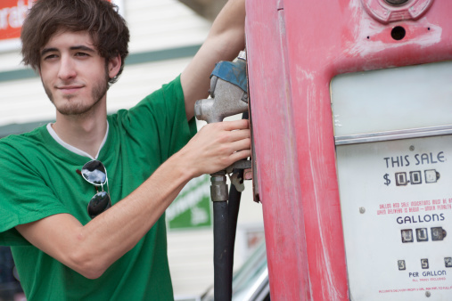 Teenager works at an old-fashioned gas station.