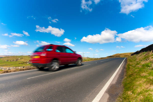 Car on a country road A car speeds by on a country road. west yorkshire stock pictures, royalty-free photos & images