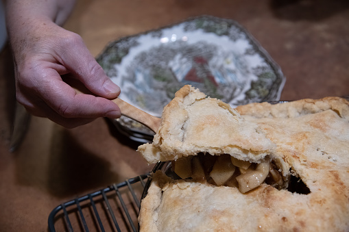 Female hand serving up a slice of hot apple pie made from fresh Montana apples in western USA of North America.
