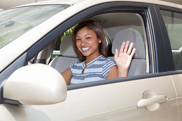 istock young woman waving her hand through car window 173907797