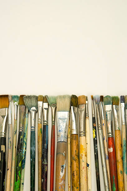 istock Well used artists paintbrushes on white paper with copy space 173908278