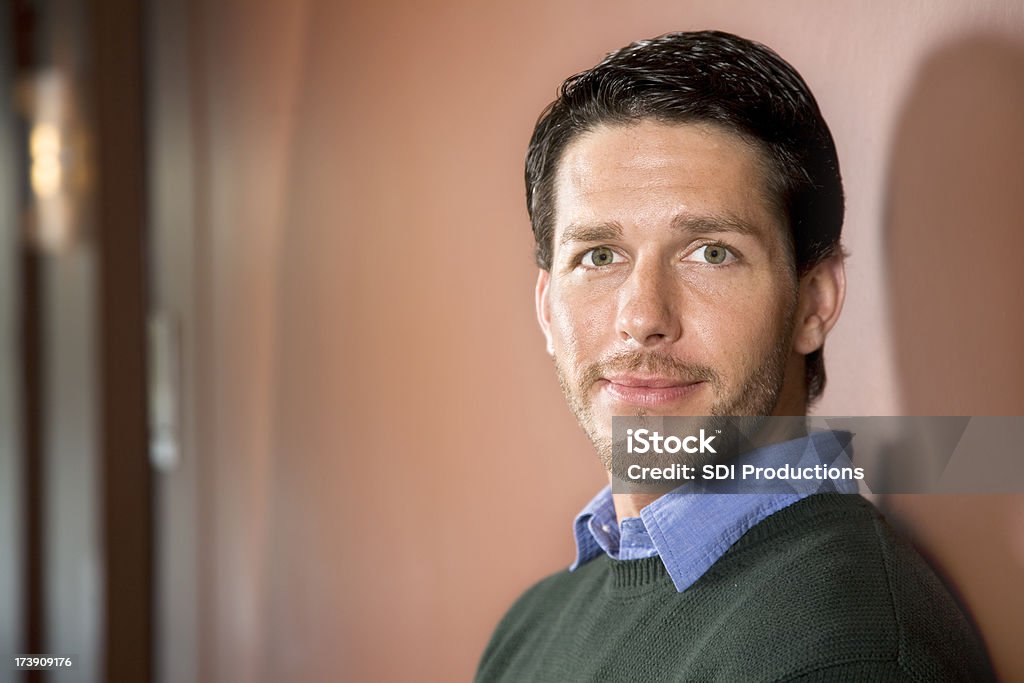 Attractive Man Standing In A Hall Way Well dressed male standing in a hall way. Church Stock Photo