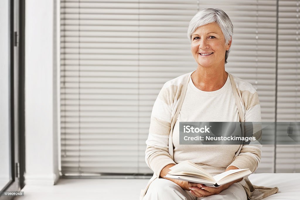 Feliz sênior mulher sentada com um bom livro - Foto de stock de 60 Anos royalty-free