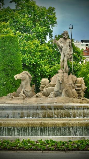 la fontana del nettuno è una fontana neoclassica in marmo bianco raffigurante il dio romano che brandisce un tridente in cima a una carrozza trainata da cavalli. - madrid neptune fountain spain foto e immagini stock