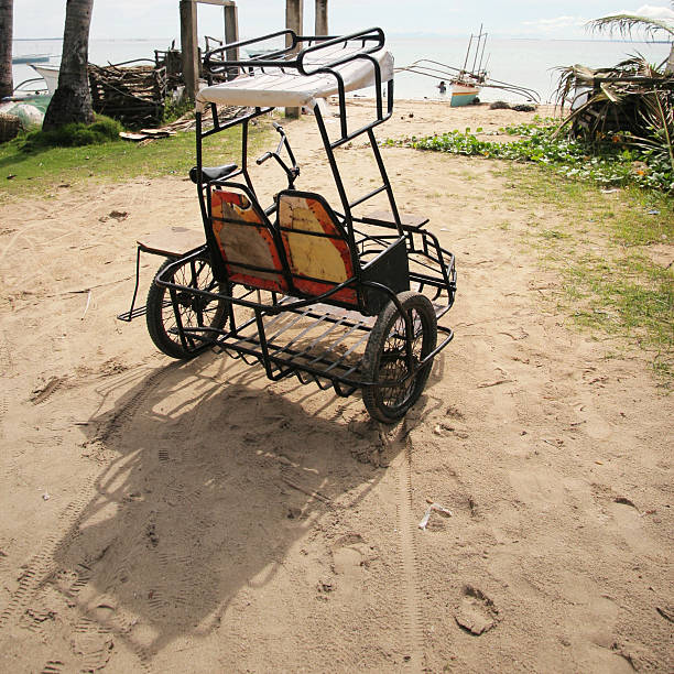 Trisikad facing the beach Trisikad or pedicab is parked facing the beach. One of the primary means of transport on Bantayan Island, Cebu, Philippines philippines tricycle stock pictures, royalty-free photos & images