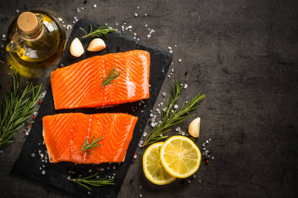 istock Salmon fish with ingredients at black table. 1739096548
