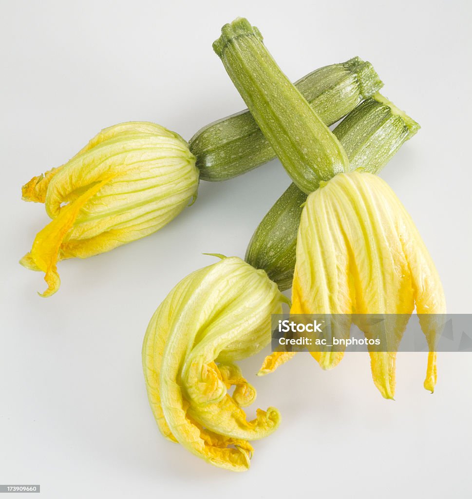 Zucchini with flowers A composition of three fresh zucchini with their flowers Food and Drink Stock Photo