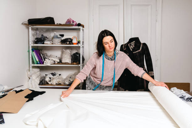 istock Seamstress works in the tailoring workshop with fabric and tools on the table 1739098731