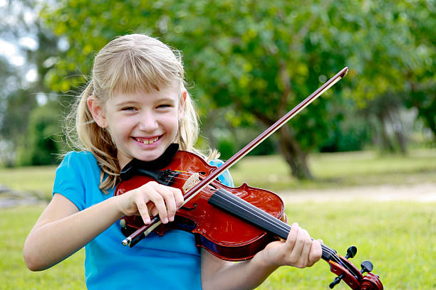istock Young little girl playing her violin outdoors smiling 173910262