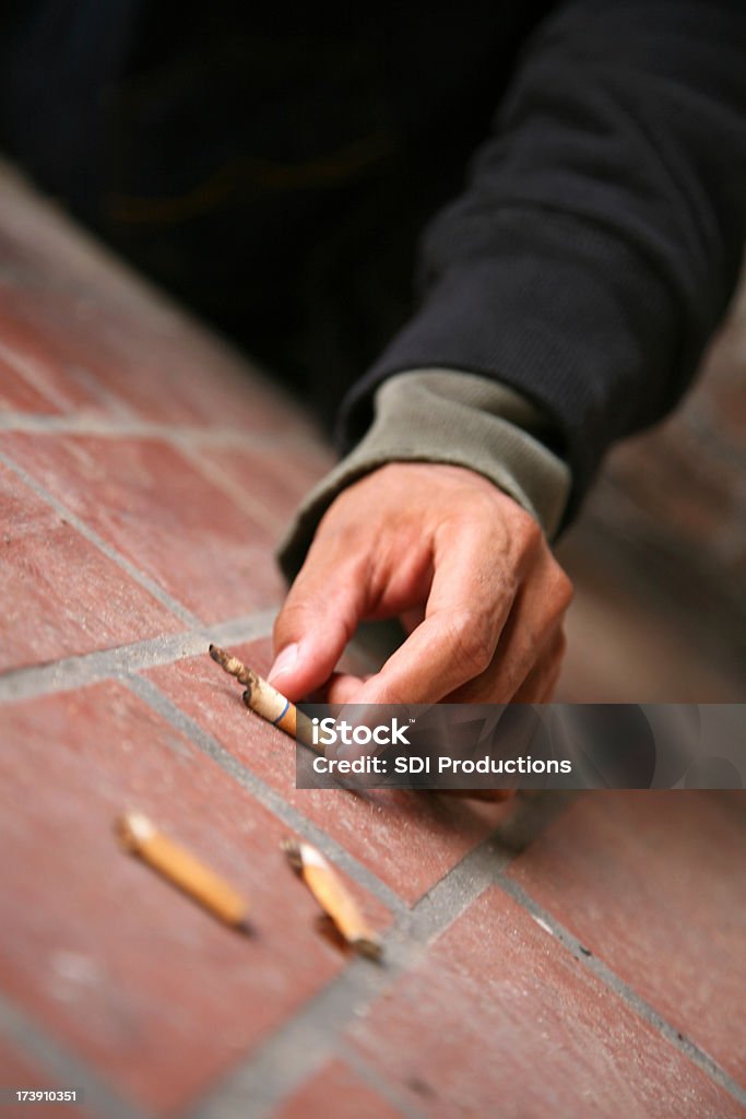 Man Reaching for a Used Cigarette Man Reaching for a Used Cigarette. Narrow Depth of Field.See more from this series: Adult Stock Photo