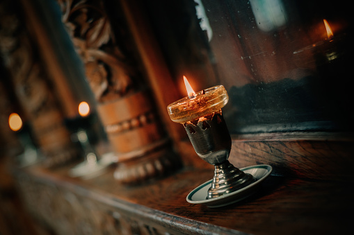 Advent and Christmas decoration, four different lit candles on a rustic wooden tray with fir branches and cookies on a table at the window, copy space, selected focus, narrow depth of field