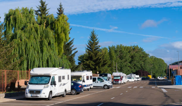 motorhomes and campervans parked on the road next to the free aire at area de autocaravanas, aguilar de campoo - palencia province imagens e fotografias de stock