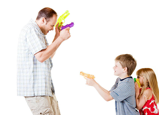 Children and Man or Father Playing with Water Guns stock photo